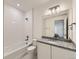 Bathroom with white tiled shower and granite countertop at 16487 E 111Th Pl, Commerce City, CO 80022