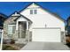 Modern two-story house with a white exterior, stone accents, and a large driveway at 16487 E 111Th Pl, Commerce City, CO 80022