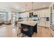 Open concept kitchen with white cabinets, an island, and a dining area at 16487 E 111Th Pl, Commerce City, CO 80022