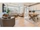 Open living space with light hardwood floors, comfortable seating, and access to a backyard patio at 16487 E 111Th Pl, Commerce City, CO 80022