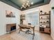Home office with built-in shelving, a large desk, and a view into the kitchen and hallway at 16487 E 111Th Pl, Commerce City, CO 80022