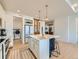Modern kitchen features a large island, laundry access, and stainless steel appliances at 16487 E 111Th Pl, Commerce City, CO 80022