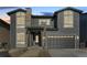Two-story home with gray siding, stone accents, and a two-car garage at 6664 Bridle Creek Pt, Castle Pines, CO 80108