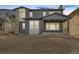Rear view of a two-story home with gray siding and a covered patio at 6664 Bridle Creek Pt, Castle Pines, CO 80108