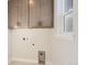 Bright laundry room with gray cabinets and tile floor at 6664 Bridle Creek Pt, Castle Pines, CO 80108