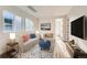 Light and airy living room featuring a comfy couch and large TV at 6664 Bridle Creek Pt, Castle Pines, CO 80108