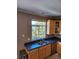 Kitchen features a double sink, wood cabinets, and a window overlooking trees at 2855 Rock Creek Cir # 158, Superior, CO 80027
