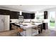 Modern kitchen with dark cabinetry, an island, and stainless steel appliances at 3833 Whispering Sage St, Evergreen, CO 80439