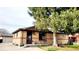 Brick ranch house with mature tree and welcoming front porch at 7071 Zuni St, Denver, CO 80221