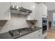 Modern kitchen with gas cooktop, stainless steel appliances, and white cabinets at 23890 E Minnow Dr, Aurora, CO 80016