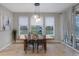 Bright dining area with wooden table, three windows, and backyard view at 23890 E Minnow Dr, Aurora, CO 80016