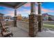 Covered front porch with stone pillars and white railing at 23890 E Minnow Dr, Aurora, CO 80016