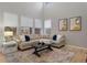 Spacious living room with L-shaped sofa, large windows, and hardwood floors at 23890 E Minnow Dr, Aurora, CO 80016