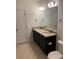 Double vanity bathroom with granite countertops, dark cabinets, and a large mirror at 4630 Copeland Cir # 102, Highlands Ranch, CO 80126