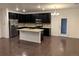 Modern kitchen with dark cabinets, granite island, and stainless steel appliances at 4630 Copeland Cir # 102, Highlands Ranch, CO 80126