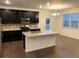 Modern kitchen with dark cabinets, granite island, and stainless steel appliances at 4630 Copeland Cir # 102, Highlands Ranch, CO 80126