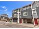 Gray townhome with red door and attached garage; community view at 8751 Pearl St # E2, Thornton, CO 80229