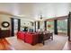 Relaxing living room with red couch, stone fireplace and large windows at 6095 Bridle Path Ln, Parker, CO 80134