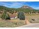 Single-story home with mountain backdrop; spacious yard and driveway at 2677 S Platte River Rd, Sedalia, CO 80135