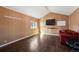 Cozy bonus room features dark hardwood floors, a red couch, and a large flat-screen TV at 2677 S Platte River Rd, Sedalia, CO 80135