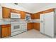 Kitchen features wood cabinets and white appliances at 12017 W New Mexico Ave, Lakewood, CO 80228