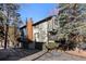 Two-story townhome with wood and gray siding, balcony, attached garage, and mountain views at 4845 Silver Spruce Ln, Evergreen, CO 80439