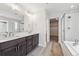 Elegant bathroom with double vanity, a large mirror, and a walk-in shower at 1401 Zenith Heights Ct, Erie, CO 80516