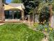 Backyard with patio, shade sail, and lush landscaping at 1324 Shadow Mountain Dr, Highlands Ranch, CO 80126