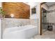 Luxurious bathroom with soaking tub, walk-in shower, and wood-like tile at 1324 Shadow Mountain Dr, Highlands Ranch, CO 80126