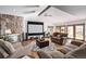 Open living room with a stone fireplace, large windows, and access to a patio at 1324 Shadow Mountain Dr, Highlands Ranch, CO 80126