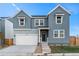 Two-story craftsman style home with gray siding, white trim, and a two-car garage at 9359 Russell Cir, Arvada, CO 80007
