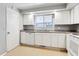 White kitchen cabinets, granite countertops and a dishwasher at 8286 E Girard Ave, Denver, CO 80231