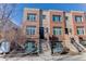 Brick front of a three-story townhome with steps leading to the entrance at 2311 Decatur St, Denver, CO 80211