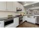 Updated kitchen, featuring white cabinets, stainless steel appliances and farmhouse sink at 2311 Decatur St, Denver, CO 80211