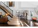 Elegant entryway with a curved staircase, hardwood floors, and views into the dining room at 6775 Saddleback Ave, Firestone, CO 80504