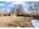 Large backyard with a wooden structure and patchy grass at 1318 S Ingalls St, Lakewood, CO 80232