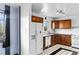 Kitchen with wood cabinets, white appliances, and tile floors at 1318 S Ingalls St, Lakewood, CO 80232