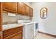 Convenient laundry room with washer, dryer, cabinets, and utility sink at 1918 S Teller St, Lakewood, CO 80227