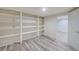 Basement storage area featuring white built-in shelves and wood-look flooring at 40 S Chase Dr, Lakewood, CO 80226