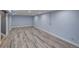 Large, open basement space with new wood-look flooring and light blue walls at 40 S Chase Dr, Lakewood, CO 80226