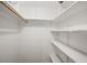 Walk-in closet with built-in white shelves and hanging rod at 1005 W 7Th Ave Dr, Broomfield, CO 80020