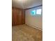 Basement bedroom with wood paneling and window at 2789 S Ivan Way, Denver, CO 80227