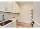 Bright laundry room with white cabinets, shelving, and a utility sink at 11442 Autumn Moon St, Littleton, CO 80125
