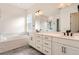 Luxurious bathroom with double vanity, soaking tub and a large mirror at 11442 Autumn Moon St, Littleton, CO 80125