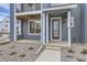 Townhome's front entrance with glass door, gray siding, and stone walkway at 2362 W 167Th Ln, Broomfield, CO 80023