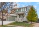 Two-story house with green and beige siding, two-car garage, and solar panels at 10569 Worchester Dr, Commerce City, CO 80022