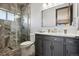 Modern bathroom with a walk-in shower, double vanity, and grey cabinets at 4923 Raintree Cir, Parker, CO 80134