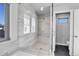 Spacious, tiled shower with modern fixtures, glass enclosure, and adjacent water closet at 2544 Chase St, Edgewater, CO 80214