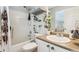 Clean bathroom with white fixtures, a shower/tub combo, and decorative plants at 82 Harlan St # B, Denver, CO 80226