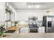 Updated kitchen with white cabinets, stainless steel appliances, and tile backsplash at 82 Harlan St # B, Denver, CO 80226